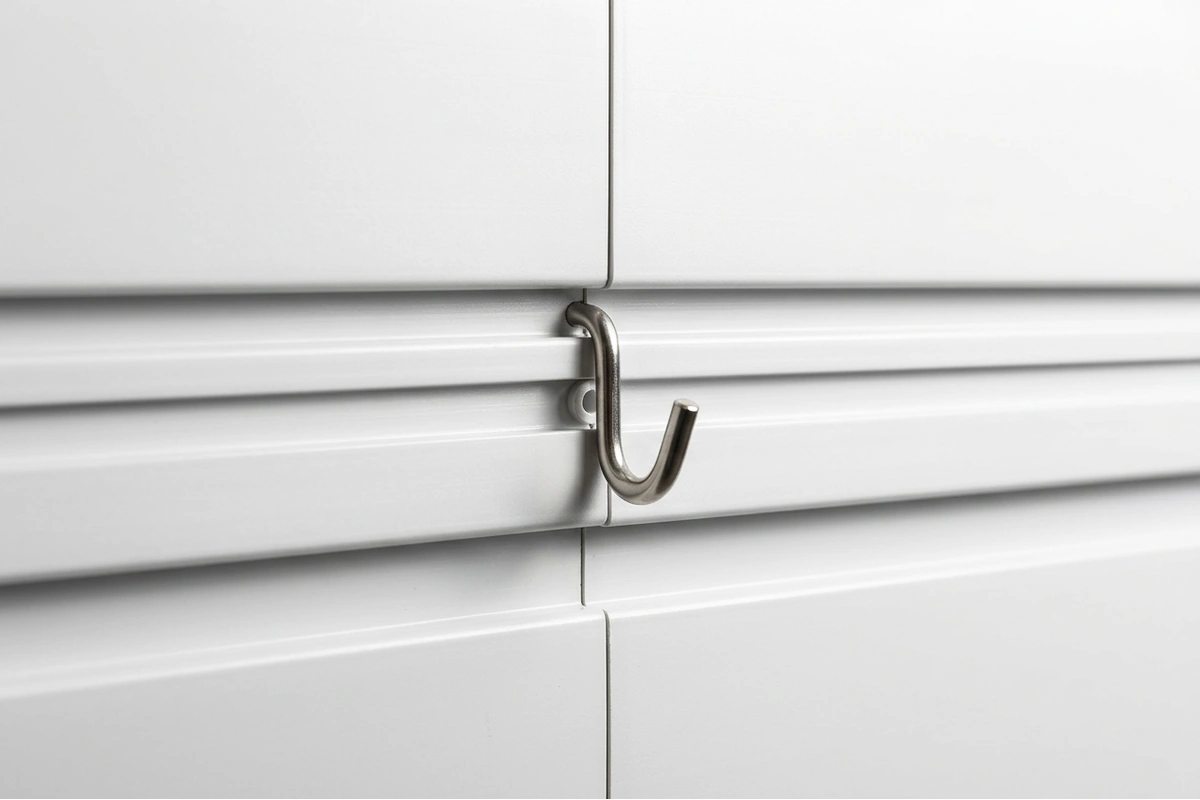 Close-up of NorskWall slatwall panel grooves showing the Kwik-Connect alignment system and a hook locked in place